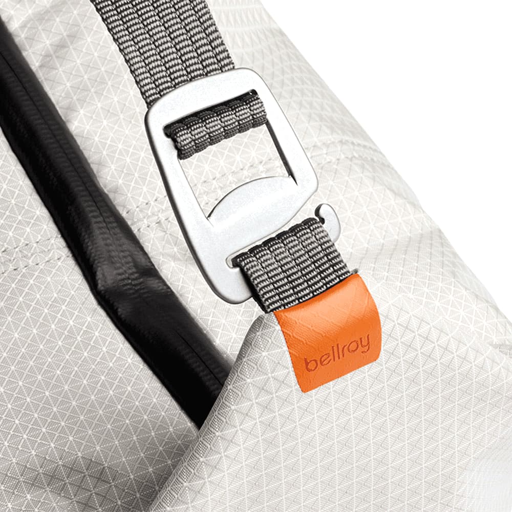 A light grey cooler bag with a handle, featuring a simple design and a logo on the side.