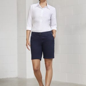 A pair of navy blue women's chino shorts displayed on a model, paired with a white shirt and casual shoes.