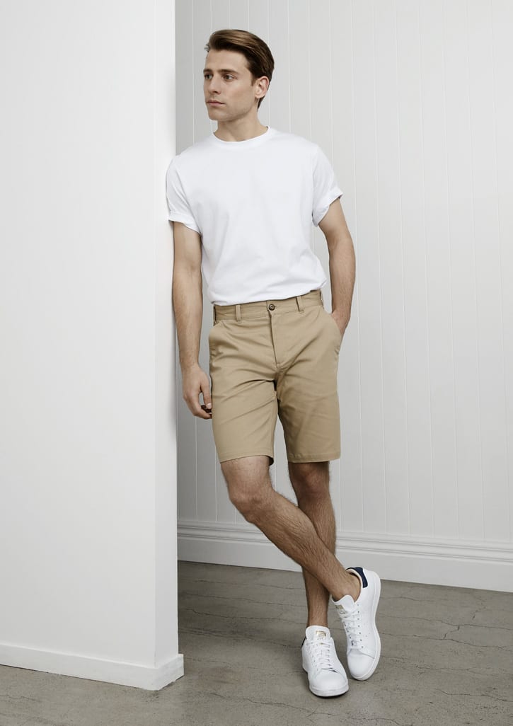 Men's shorts in khaki, featuring a button closure and pockets, styled with a white t-shirt and white sneakers.
