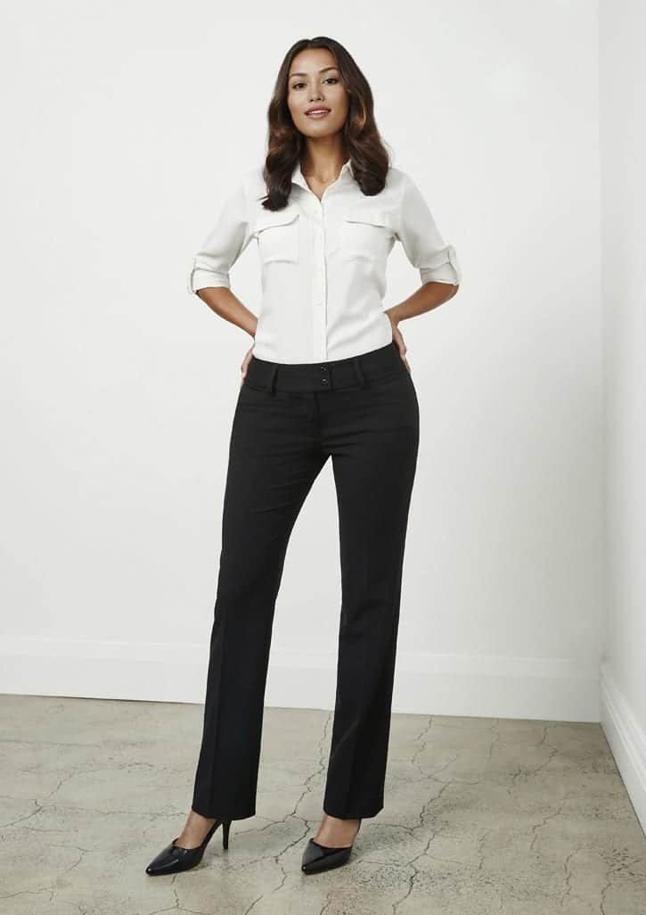 A pair of women's black slacks featuring a tailored fit, styled with a white shirt and heels, standing on a concrete floor.