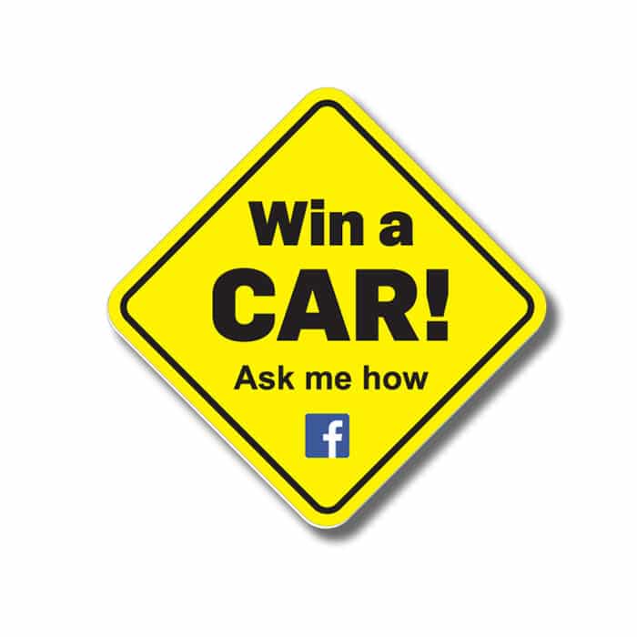 A yellow diamond-shaped sign featuring bold black lettering and a logo, advertising a car giveaway.