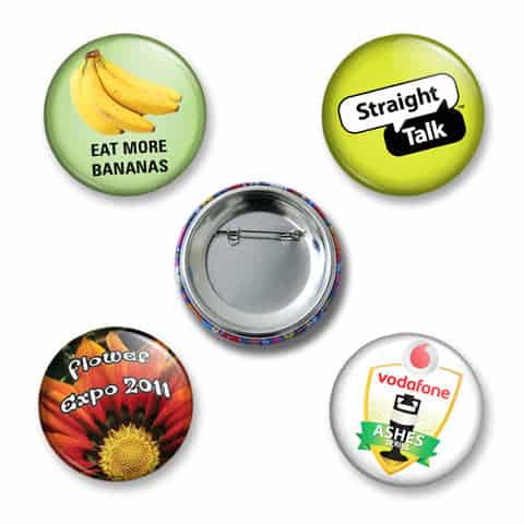 Five button badges featuring various designs, including bananas, a flower, and a logo, with a silver backing.
