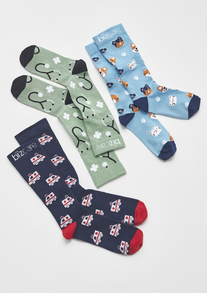 Unisex Happy Feet Comfort Socks in green with medical symbols, blue with animals, and navy with emergency vehicles.