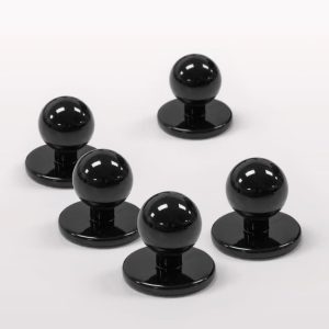 A set of five black chef jacket buttons with a round top and a flat base.