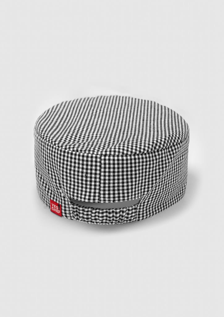 A black and white checked chef cap with a branding label on the side.