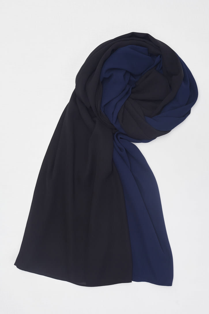 A women's hijab featuring a blend of black and navy blue fabric, elegantly draped.