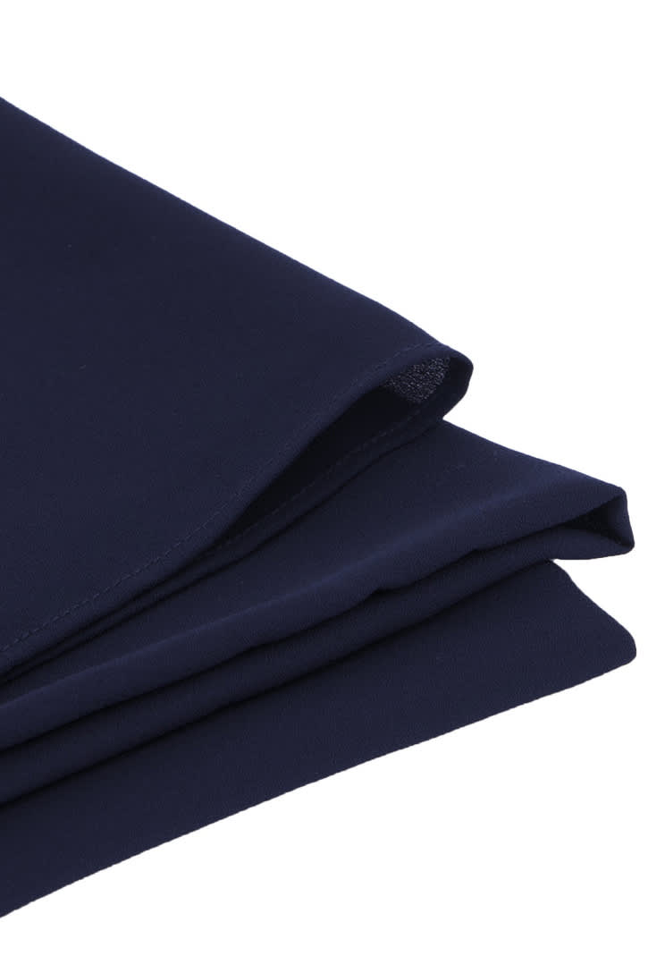 A navy blue women's hijab with a smooth texture, neatly folded. The fabric appears lightweight and drapes elegantly.