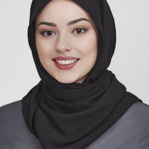 A black women's hijab worn by a smiling woman, featuring a smooth fabric and a simple style.