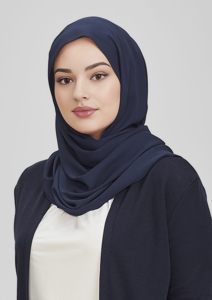 A navy women's hijab worn with a white top, featuring a smooth fabric and a simple design.