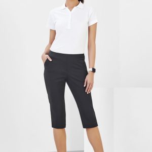 3/4 length stretch pants in black worn by a woman, featuring pockets and a sleek design. Model stands against a plain background.