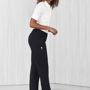 A woman wearing black women's cargo pants paired with a white shirt and white sneakers, standing on a light background.