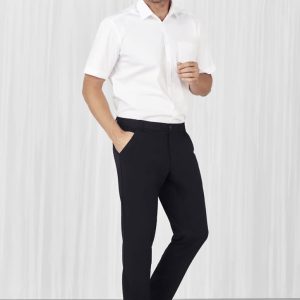 A man models black flat front slacks paired with a white shirt, showcasing a sleek, casual style.