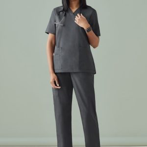 A model wearing black Women's Tokyo Scrub Pant paired with a matching top, featuring pockets and a logo.