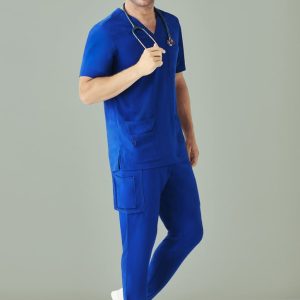 A man wearing royal blue scrub top and matching straight leg scrub pants, holding a stethoscope, against a light background.
