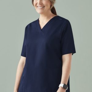 A woman models a navy scrub top featuring a V-neck and side pockets, with a logo on the sleeve.