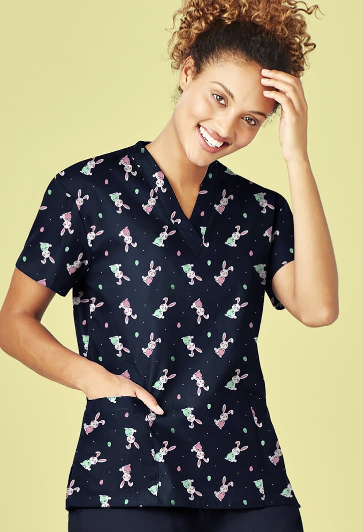 A navy V-neck scrub top featuring a playful Easter-themed pattern, with short sleeves and a pocket.