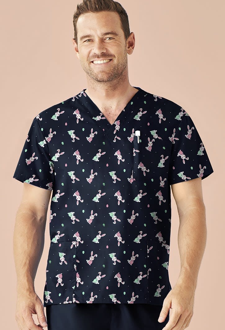 A men's V-neck short sleeve scrub top in navy with a colourful Easter-themed pattern featuring bunnies.