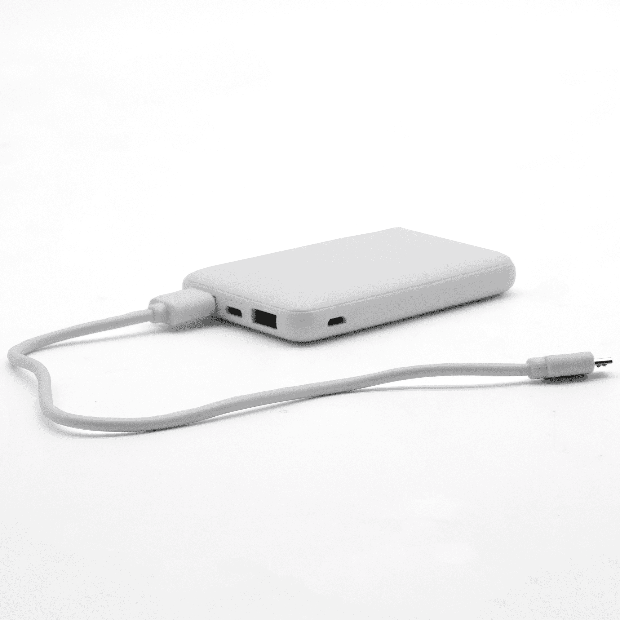 A white power bank with a USB cable connected, featuring ports for charging devices.
