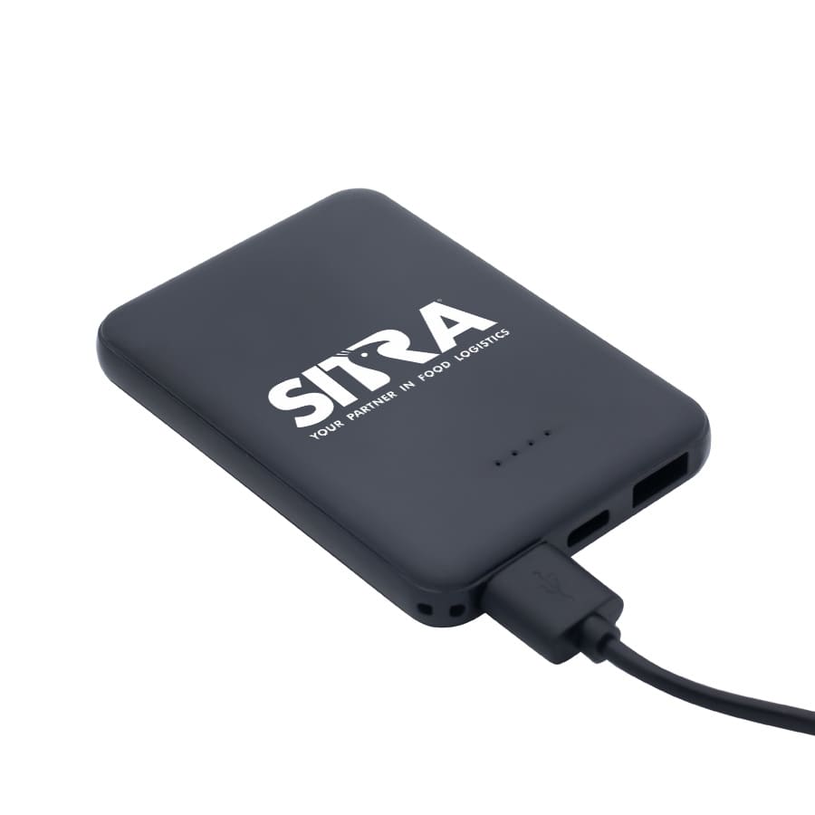 A black power bank with a logo, featuring USB ports and a charging cable connected.