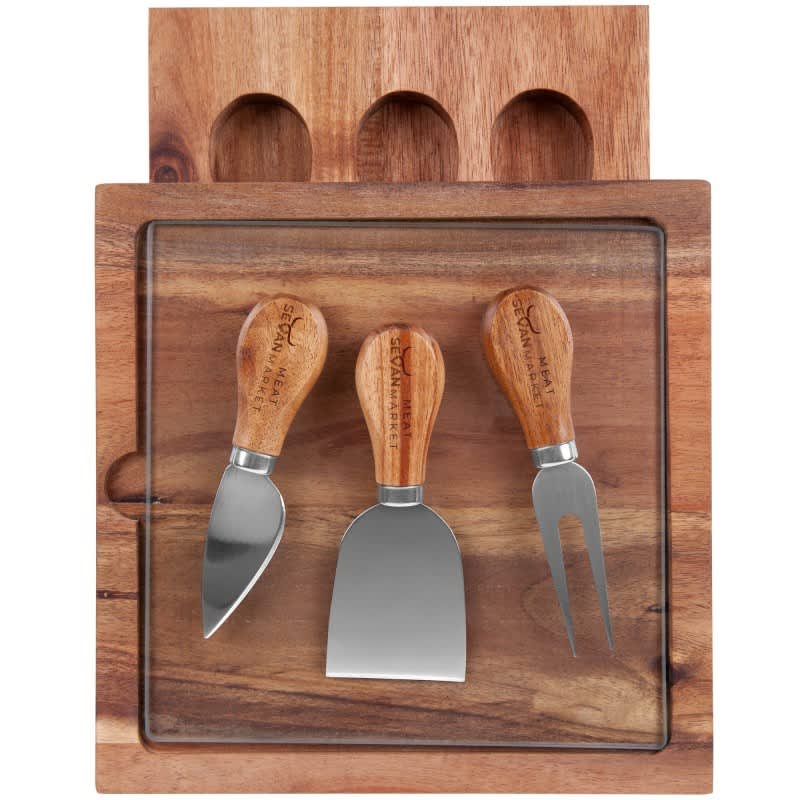 A wooden cheese board with a glass top and three stainless steel cheese knives featuring wooden handles.