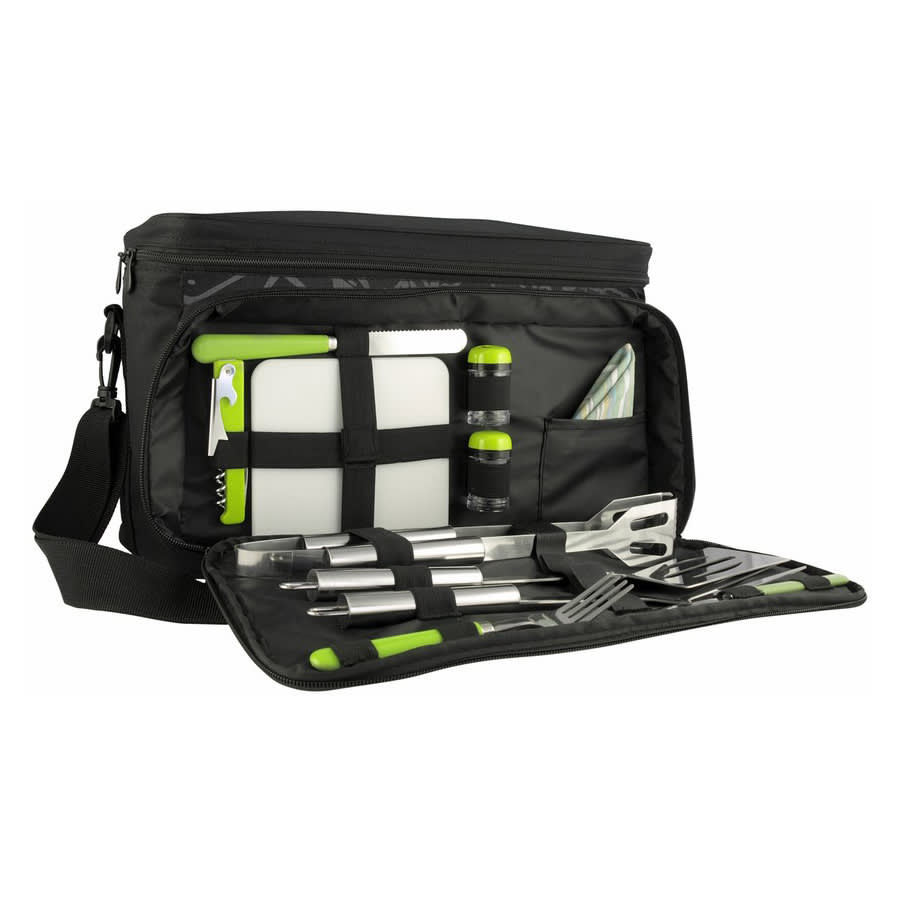 A black picnic bag with green accents, containing utensils, a cutting board, drink bottles, and a napkin.