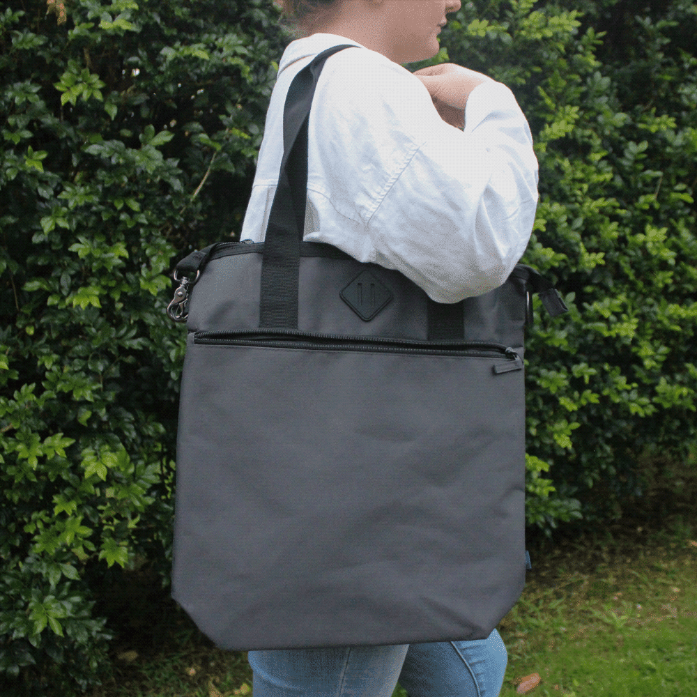A grey laptop tote bag made from Repreve recycled material, featuring shoulder straps and a logo.