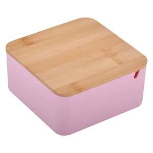 A square pink beauty case with a bamboo lid and a small red detail. It has a logo on the front.
