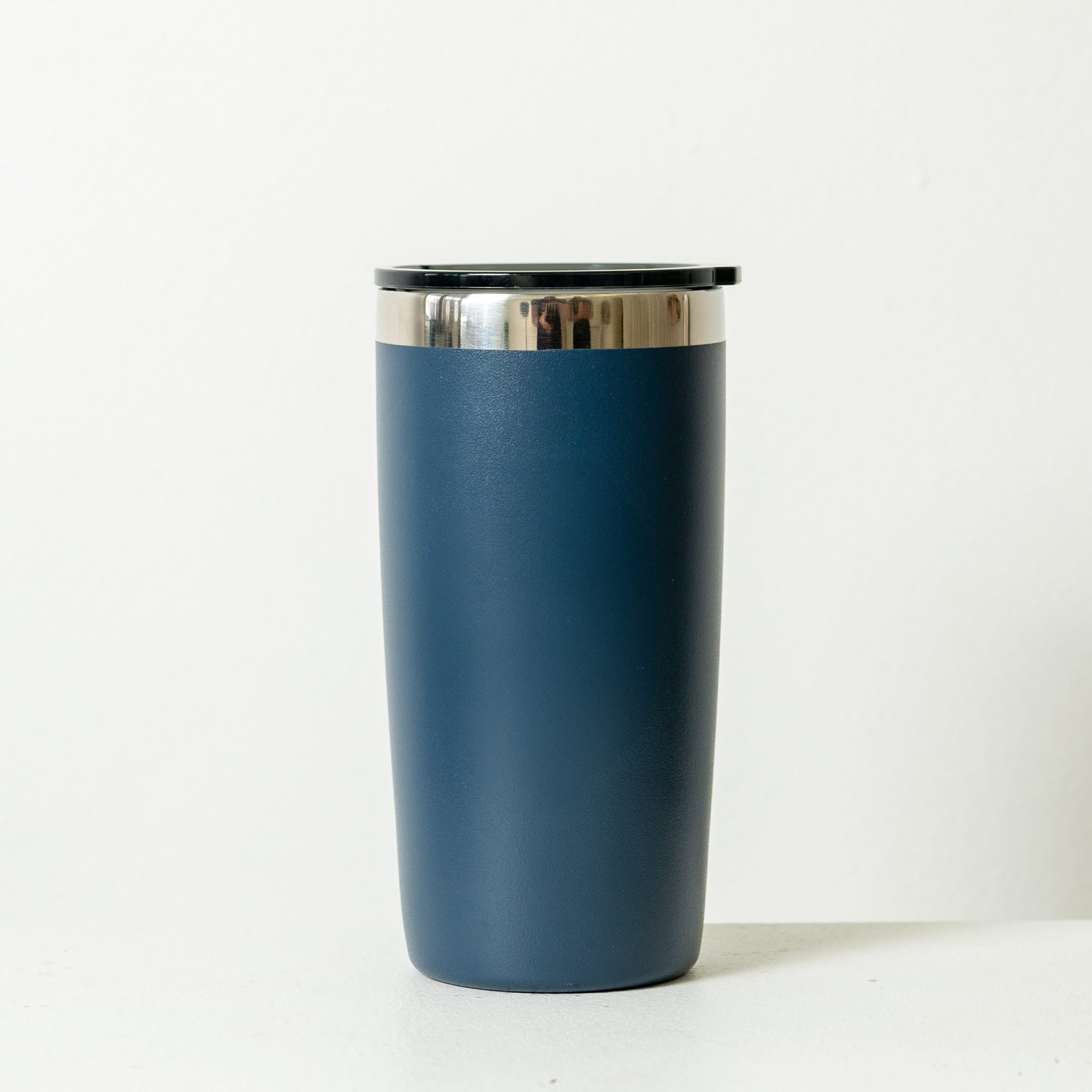A drink bottle in matte black with a silver rim and a black lid. It features a branding logo.
