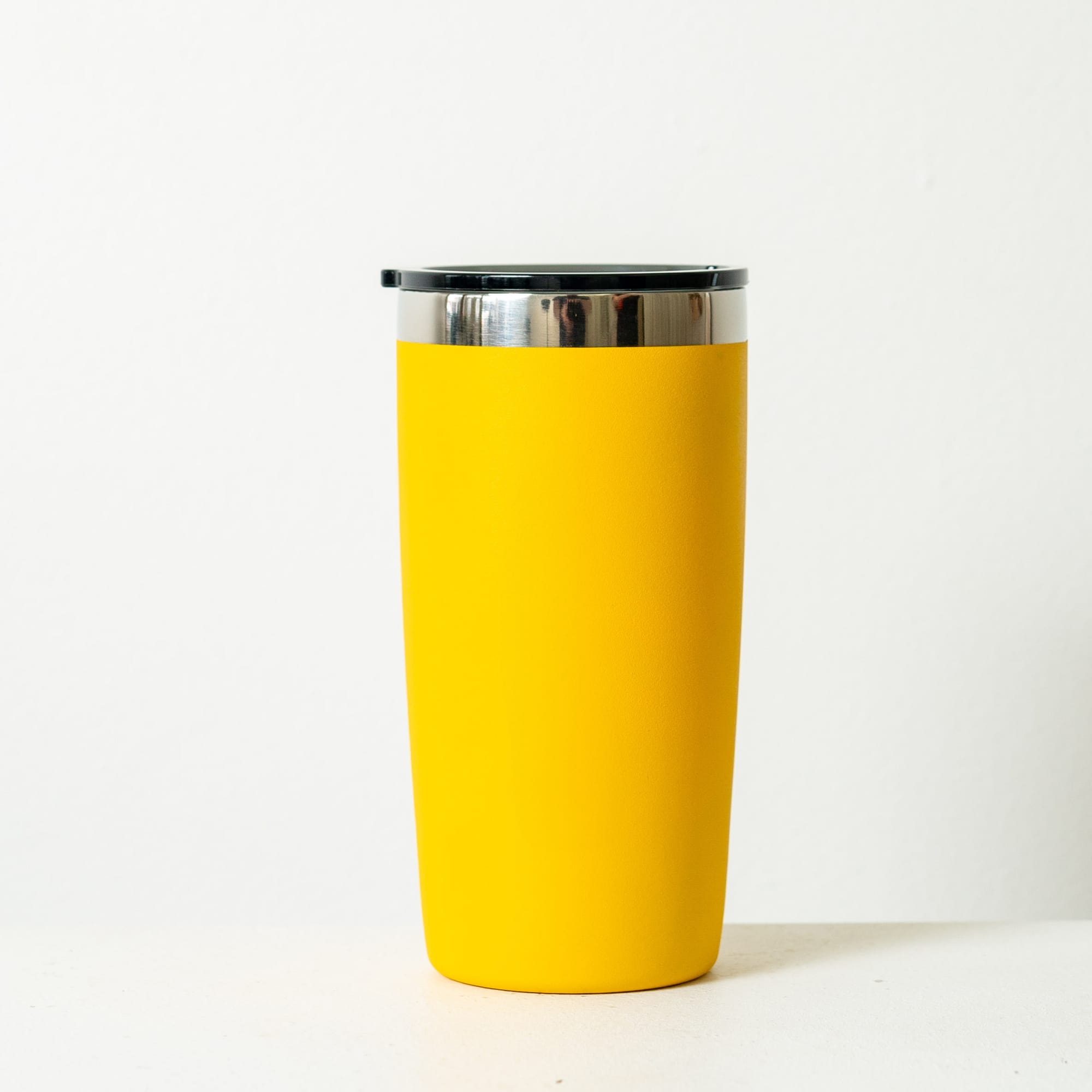 A drink bottle in a vibrant turquoise colour with a stainless steel rim and a black lid. It features a logo.