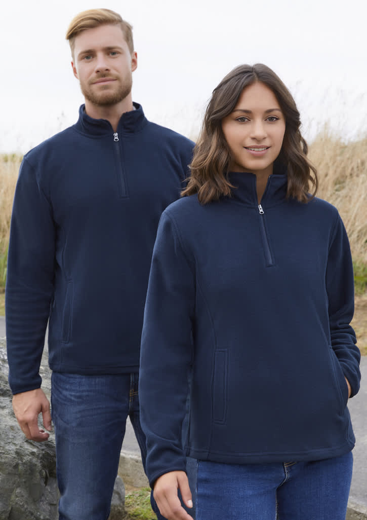 A navy fleece jacket featuring a half-zip design, displayed on both male and female models in an outdoor setting.