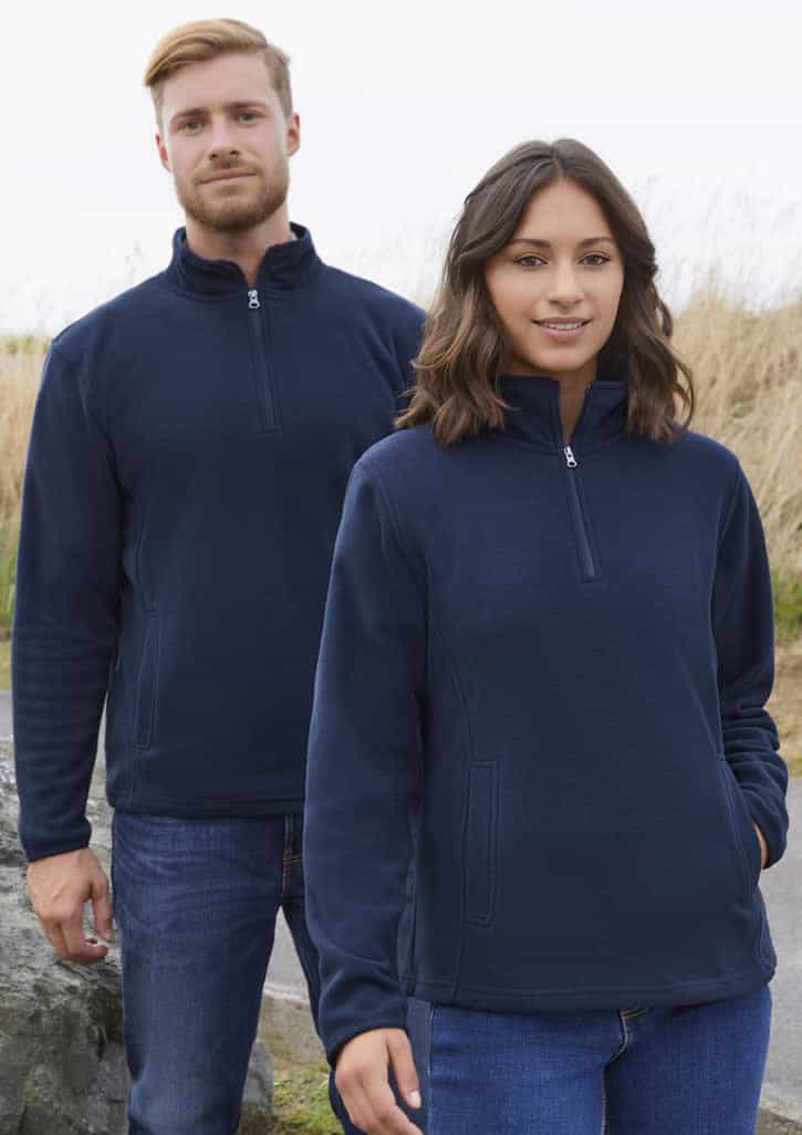 A navy fleece jacket featuring a half-zip design, displayed on both male and female models in an outdoor setting.