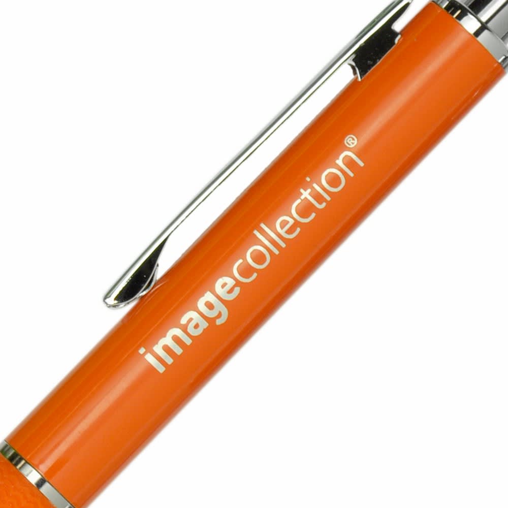 An orange metal pen with a shiny silver clip and branding on the barrel.