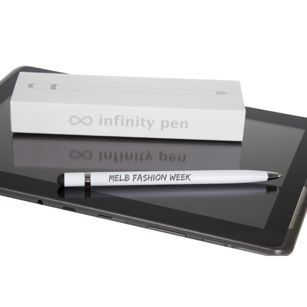 A white metal pen rests on a tablet beside a white box featuring a logo for the Infinity Pen.
