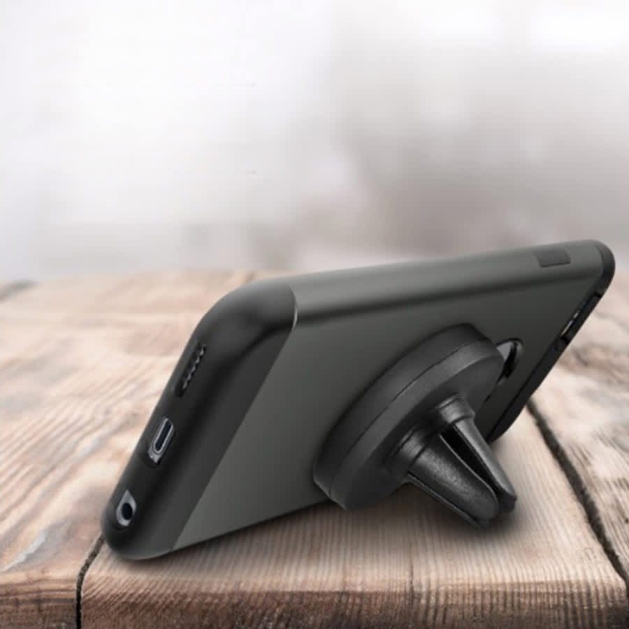 A black universal magnetic car mount attached to a smartphone, positioned on a wooden surface.