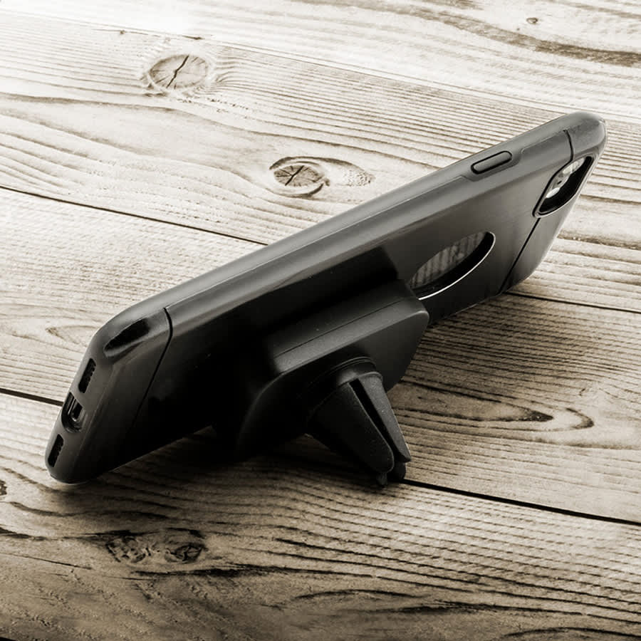 A black universal magnetic car mount for phones, positioned upright on a wooden surface, with a subtle branding logo.
