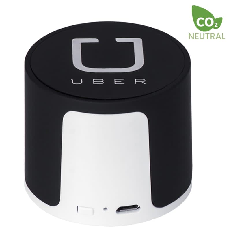 A black and white wireless speaker featuring a logo and a USB port. The design is cylindrical and compact.