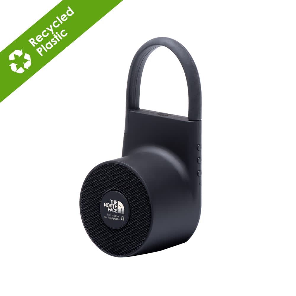 A black wireless outdoor speaker made from recycled ABS, featuring a handle and buttons on the side.