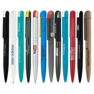 A collection of metal ballpoint pens in various colours, featuring logos and brand names, arranged in a line.