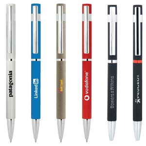 A collection of slim metal pens in silver, blue, brown, red, black, and textured finishes, featuring various logos.