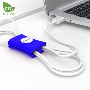 A blue cable manager designed to organise cables, placed next to a laptop and connected to a USB port.
