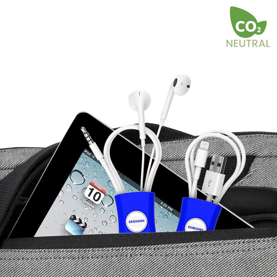 A blue cable manager holds earphones and a charging cable within a bag, with a tablet partially visible.