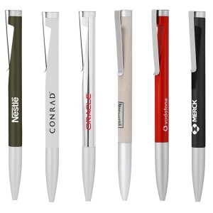 A collection of six metal ballpoint pens in various colours including olive green, white, silver, beige, red, and black, with branding.