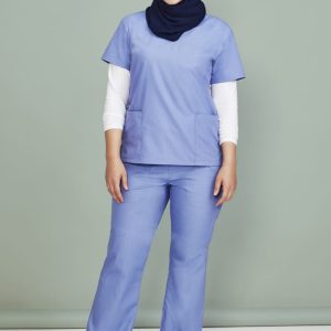 A model wearing light blue classic women's bootleg scrub pants paired with a matching scrub top and a navy hijab.