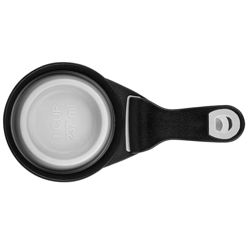A collapsible silicone pet food scoop in black, featuring a metallic measuring cup and a handle with a loop for easy storage.