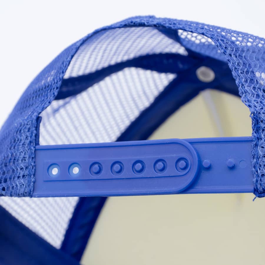 A blue trucker cap featuring a mesh back and an adjustable plastic strap for sizing. The cap has a logo.