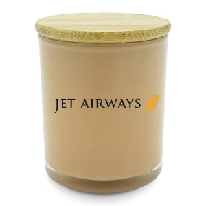 A medium relax candle in a peach-coloured glass jar with a bamboo lid and a branding logo.