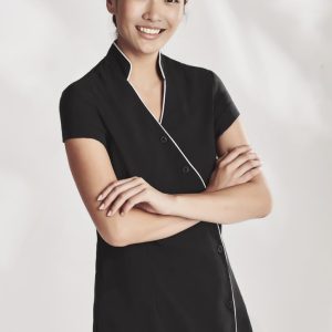 A black women's crossover tunic with short sleeves and white piping, featuring a button closure and a logo.