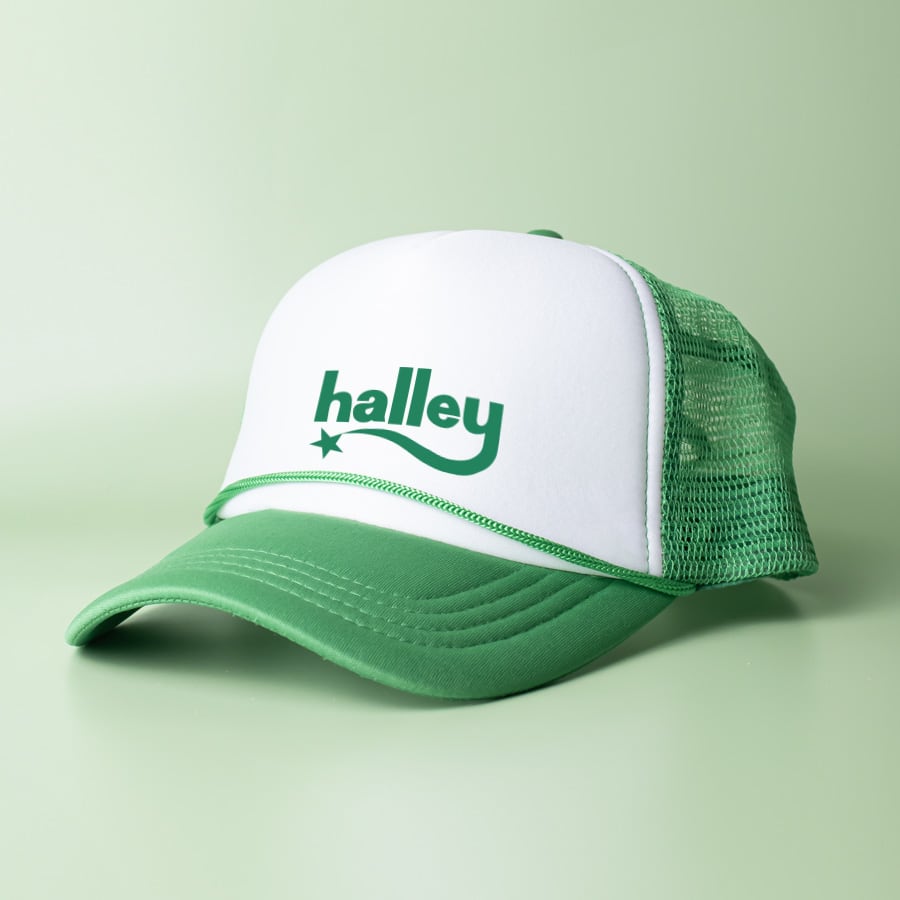 A green and white trucker cap with a mesh back and a logo on the front.