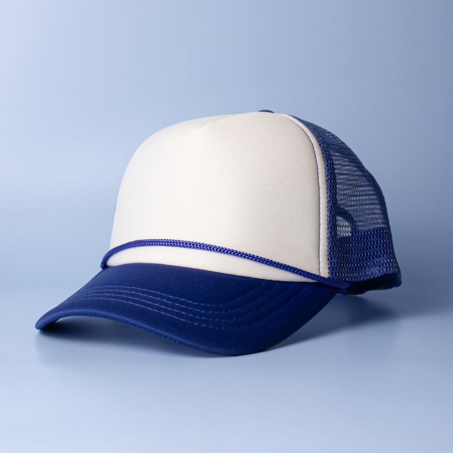 A trucker cap in cream and navy blue with a mesh back and a curved brim. It features a logo on the front.