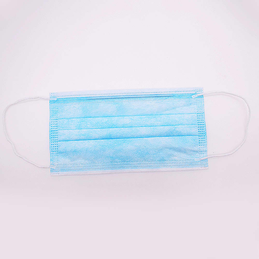 A triple layered cloth face mask in light blue, featuring ear loops and a pleated design, with a logo present.